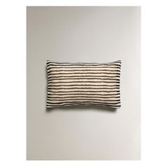 a black and white striped pillow sitting on top of a wall