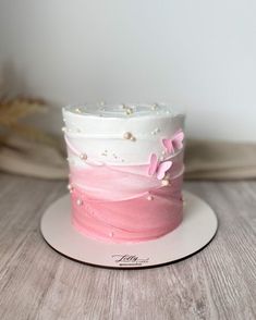 a pink and white cake with flowers on top