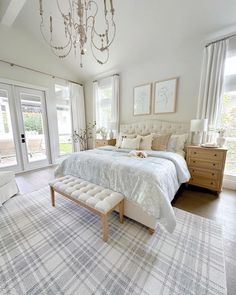 a large white bed sitting inside of a bedroom