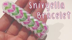 a hand holding a pink, green and white braided rubber bracelet with the words smilybella braclet on it