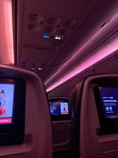 the inside of an airplane with two televisions