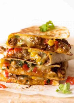 two quesadillas stacked on top of each other with meat and vegetables in the middle