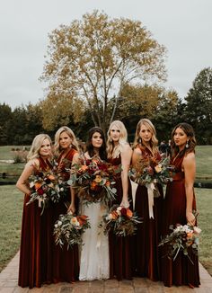 a group of women standing next to each other holding bouquets