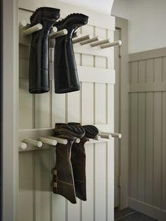 there are two pairs of shoes hanging from the hooks on the wall next to each other