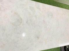 a white marble slab with green grass in the background