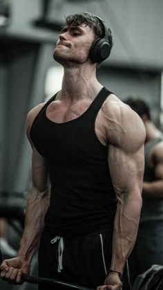 a man with headphones standing in the gym