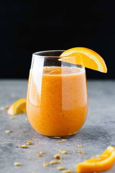 Orange carrot basil smoothie in a glass.