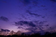 the sky is purple and blue with some clouds