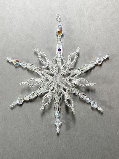 a crystal snowflake ornament is shown on a gray surface with white background