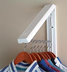 clothes are hanging on hangers in front of a mirror