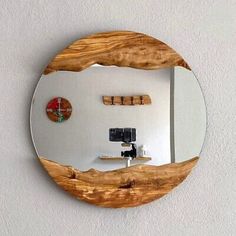 a round mirror mounted to the side of a wall next to a wooden table top