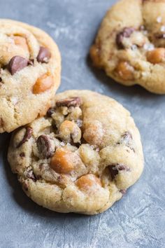 three chocolate chip cookies sitting on top of a table