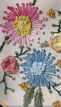 a close up of a embroidery on a piece of cloth with flowers in the middle