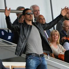 a man with his hands up in the air at a soccer game while people look on