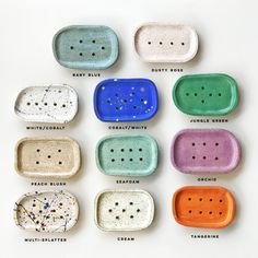 nine different colored dishes with holes in them on a white surface, each containing six different types of dots