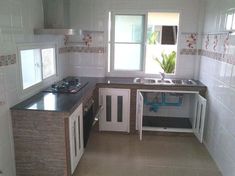 a kitchen with white walls and tile flooring next to a stove top oven under a window