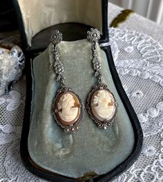 Featuring a gorgeous pair of antique 1910s-20s Edwardian Belle Époque rhodium plated screw back drop  earrings adorned with luminous genuine carved conch shell cameos set in decorative open back pronged settings.  These beauties are in excellent condition with  a lovely patina with all stones intact and accounted for.  Earrings measure approximately 2  inches long at 7.7  grams respectively.  Beautifully designed and handcrafted, elegant and sophisticated! Please feel free to contact me with any Vintage White Gold Dangle Jewelry, Victorian Dangle Earrings For Formal Occasions, Victorian Screw Back Wedding Jewelry, Antique Dangle Earrings From Vintage Collection, Antique Dangle Earrings For Vintage Collection, Nickel-free Antique Silver Jewelry, Antique White Gold Wedding Earrings, Antique Silver Vintage Dangle Jewelry, Victorian Screw Back Wedding Earrings