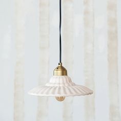 a white and gold light hanging from a ceiling