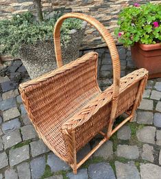 a wicker basket sitting on top of a stone floor next to potted plants