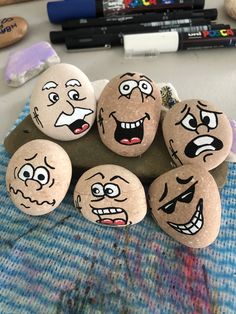 five rocks with faces painted on them