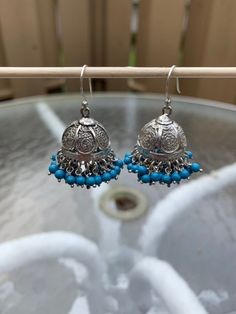 "I have accented a filigree jhumka base liberally with blue beads. These are an adornment to your earlobes. Pair this with any outfit you can dream of, you will not be disappointed.  These are famous in Jaipur, Rajasthan and Lucknow, filigree jhumkas are a rage and works well with any outfit. Total length is 1.5\". Metal - Sterling Silver. Please feel free to ask me for more pictures or questions. Thank You for Shopping Jhumkas they are Ancient, Elegant, Opulent and Regal!" Blue Festival Earrings With Latkans, Blue Latkans Jewelry For Festival, Bohemian Blue Chandbali Jewelry, Traditional Jhumkas With Dangling Beads For Diwali, Traditional Blue Earrings With Intricate Design, Traditional Jhumkas With Dangling Beads For Festivals, Blue Dangling Beads Jewelry For Festivals, Blue Tilla Jhumkas For Festivals, Blue Chandbali Jhumkas With Latkans