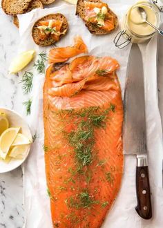 a large piece of fish sitting on top of a table next to other foods and utensils