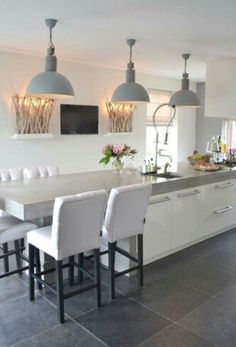 a kitchen with white chairs and an island