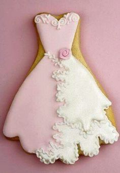 a decorated wedding dress cookie on a pink background