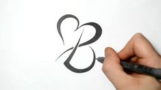 someone is drawing a heart on paper with a marker and pencils in their hands