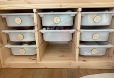 several plastic containers are stacked on top of each other in a storage unit with wooden shelves