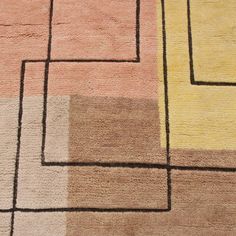 an area rug with squares and rectangles in various shades of pink, yellow, brown, and beige