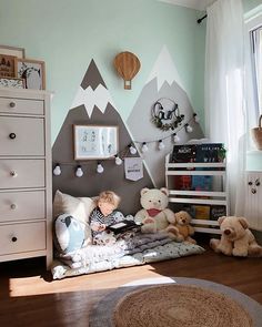 a child's bedroom with teddy bears and mountains on the wall