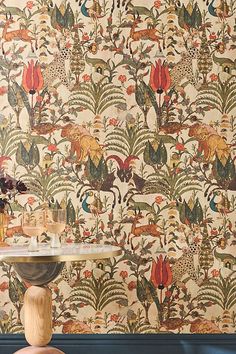 a wallpapered room with a table and vases on the top of it