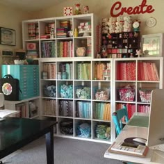 a room filled with lots of crafting supplies and bookshelves next to a desk