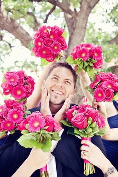 a man and woman holding bouquets of pink flowers