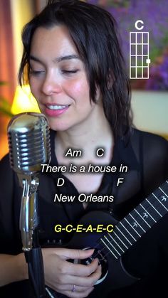 a woman holding a guitar in front of a microphone with the words, am c there is a house in d new orleans