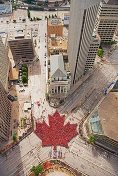 an aerial view of a large canadian maple leaf in the middle of a city street