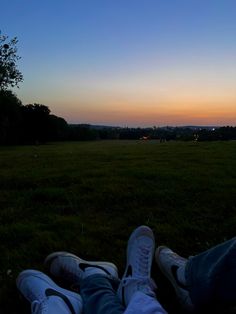 the person is laying down on the grass with their feet up in front of them