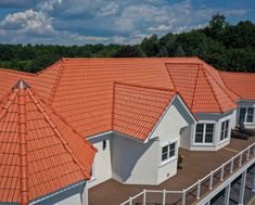 an aerial view of several houses with orange roof tiles and white trim on the roofs