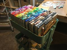 a cart filled with lots of different colored crayons on top of a table