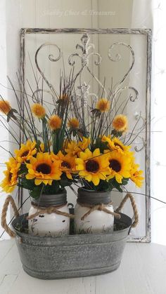 sunflowers and mason jars are arranged in a bucket