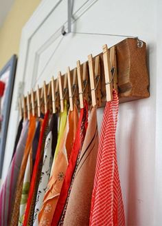 an image of clothes hanging on a rack in front of a wall mounted coat rack