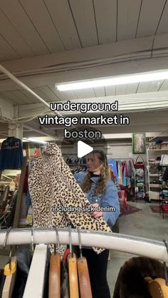 a woman is looking at an animal print scarf in a store with the caption under ground vintage market in boston