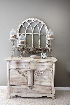 an old dresser with a mirror on top and candles in the bottom drawer next to it