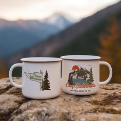 two coffee mugs sitting on top of a rock