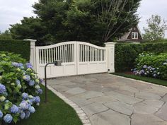 a white fence with blue hydrangeas around it