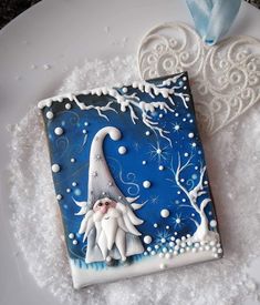 a blue and white frosted square shaped cookie with an image of a gnome on it