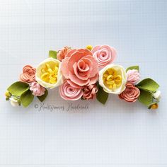 an arrangement of paper flowers on a white surface