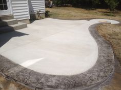 a concrete patio with steps leading up to the house