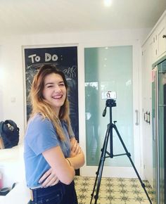 a woman standing in front of a camera